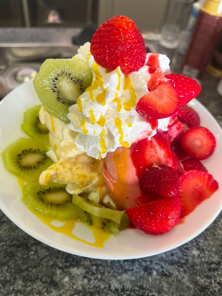 Fruchtiger Eisbecher mit Erdbeeren, Kiwi und Sahne